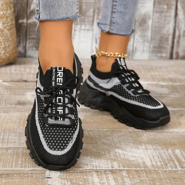 Black orthopaedic breathable trainers on model
